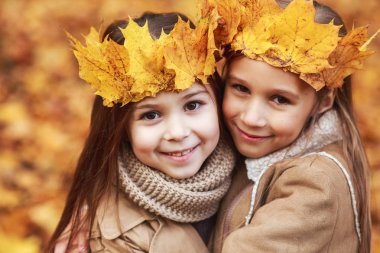 Sevimli iki küçük kız sonbahar parkta sarılma