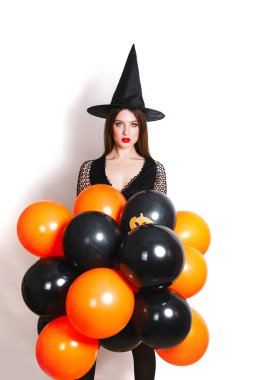 İçinde Kara Cadı halloween kılık beyaz arka plan üzerinde turuncu ve siyah Balonlu güzel seksi genç kadın portresi