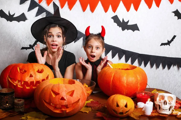 Vicces anya és lánya otthon érzik magukat. Boldog család felkészülés Halloween. Emberek visel Farsangi jelmezek. — Stock Fotó