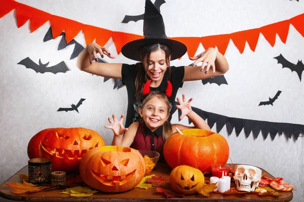 Komik anne ve kızı evde eğleniyor. Mutlu bir aile Cadılar Bayramı için hazırlanıyor. Karnaval kostümleri giyen insanlar. — Stok fotoğraf