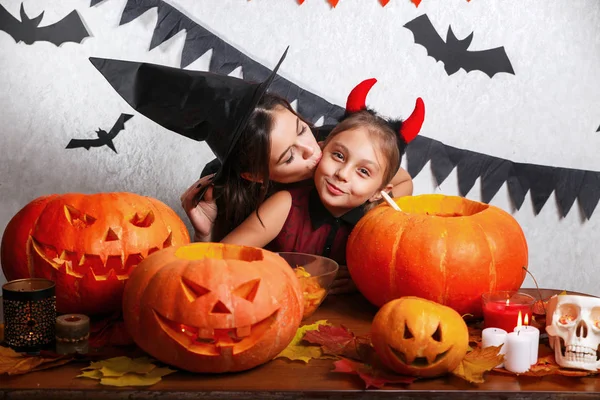 Lustige Mutter und Tochter, die zu Hause Spaß haben. glückliche Familie bereitet sich auf halloween vor. Menschen in Karnevalskostümen. — Stockfoto