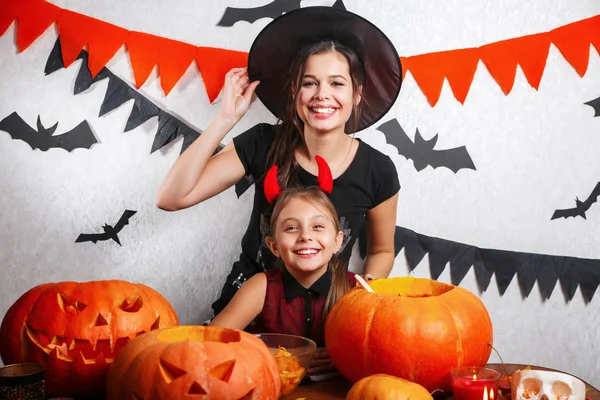 Lustige Mutter und Tochter, die zu Hause Spaß haben. glückliche Familie bereitet sich auf halloween vor. Menschen in Karnevalskostümen. — Stockfoto