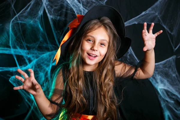 Boldog halloweent. Kis boszorkány gyerek szórakozik, pókháló és ívelt sütőtök háttérrel. — Stock Fotó