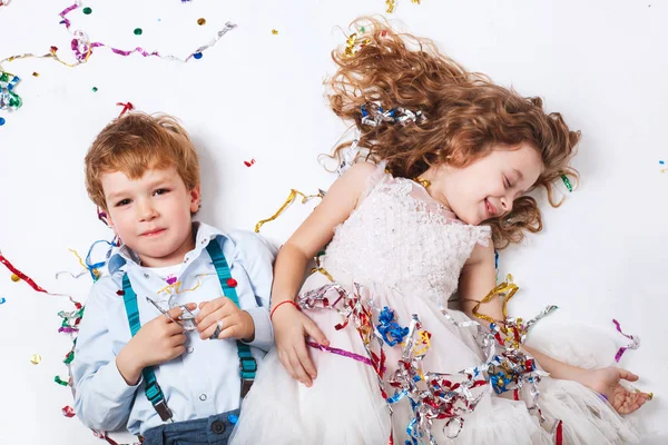 有趣的快乐的女孩和小男孩庆祝生日派对 微笑着躺在五颜六色的五彩纸屑 — 图库照片