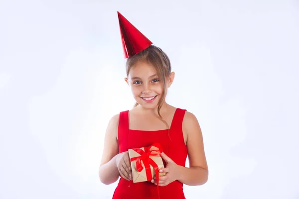 可爱的小女孩在生日帽拿着红色礼物 — 图库照片
