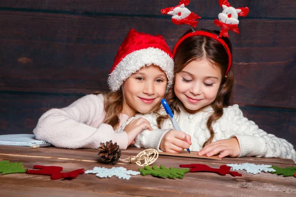 Two little girls writing letter to Santa Claus. Christmas concept.