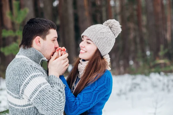 Boyfriend warms hands sweetheart, frozen in the cold — Stock Photo, Image