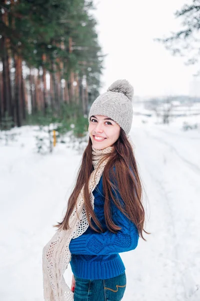 Giyen genç güzel esmer kadın portresi kış karla kaplı viskisini ördü. Kış orman kadında