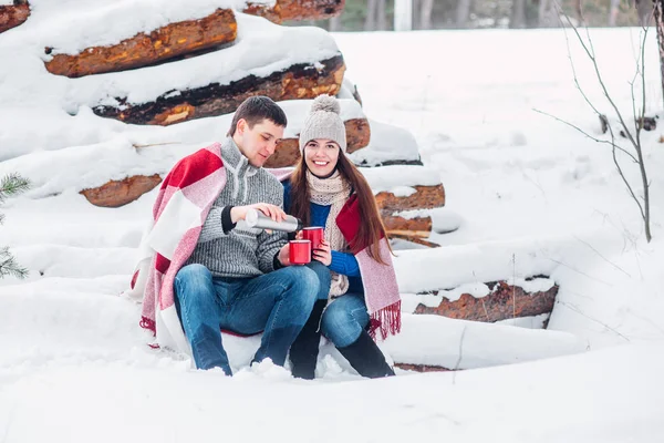 Retrato de jovem casal feliz desfrutando de piquenique no parque de inverno nevado — Fotografia de Stock