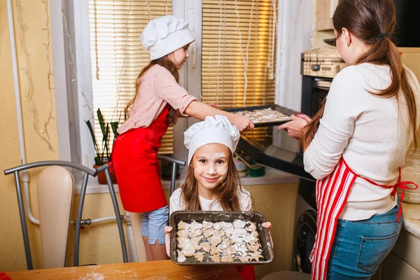 Семья с детьми готовит печенье на Рождество на кухне — стоковое фото