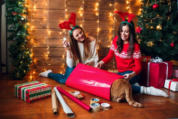 Φίλοι, έχοντας μια διασκεδαστική ενώ προετοιμάζει διακοσμήσεις Χριστουγέννων — Φωτογραφία Αρχείου