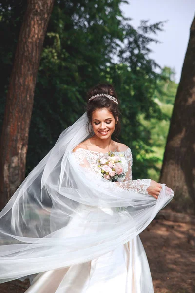 Hermosa novia en vestido de novia de moda sobre fondo natural. Día de la boda . — Foto de Stock