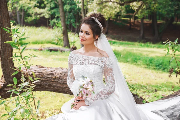 Krásné šťastné nevěsty s kyticí v parku — Stock fotografie