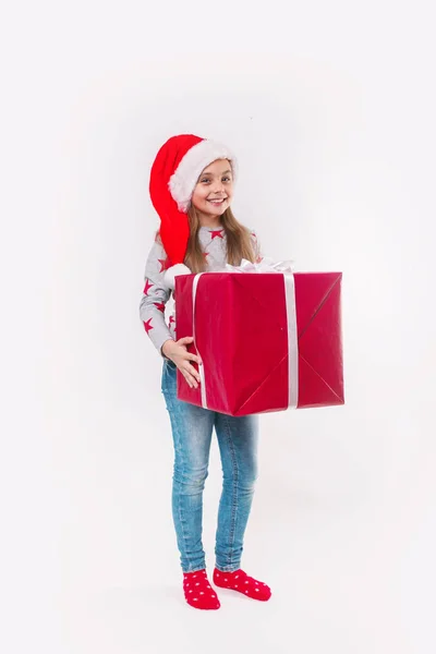 Sonriente niño divertido en Santa sombrero rojo con regalo de Navidad en la mano. Concepto de Navidad. —  Fotos de Stock