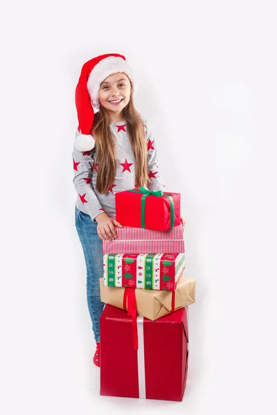 Счастливый ребенок в красной шляпе Санта держит рождественские подарки. Концепция Рождества . — стоковое фото