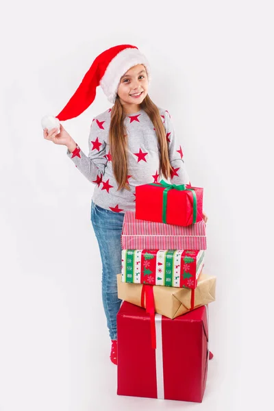 Счастливый ребенок в красной шляпе Санта держит рождественские подарки. Время Рождества. — стоковое фото