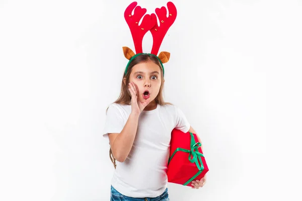 Niño en cuernos de ciervo sosteniendo la caja de regalo de Navidad en la mano sobre fondo blanco. Concepto de Navidad . —  Fotos de Stock