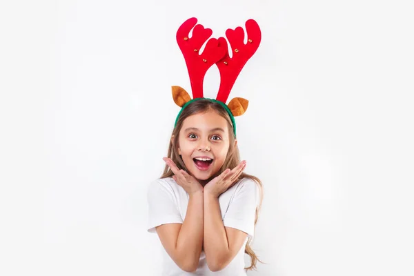 Enfant drôle souriant en cornes de cerf et t-shirt blanc faisant surprise et regardant la caméra  . — Photo