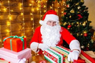 Mutlu Noeller ve mutlu tatiller. Noel Baba hediye çocuklar için evde masa başında Xmas için hazırlanıyor.