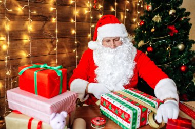 Mutlu Noeller ve mutlu tatiller. Noel Baba hediye çocuklar için evde masa başında Xmas için hazırlanıyor.