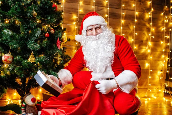 Jultomten nära julgran med gåvor. Juletid — Stockfoto
