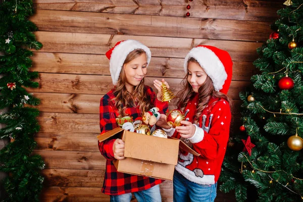 Καλά Χριστούγεννα και καλές γιορτές. Χαριτωμένο μικρό αδελφές στολίζουν το δέντρο στο σπίτι. — Φωτογραφία Αρχείου
