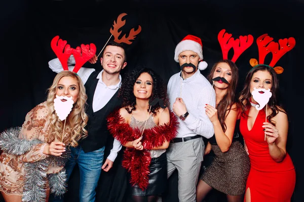 Seis jovens amigos engraçados, quatro meninas e dois meninos enquanto comemoram o Natal. Grupo de amigos no clube se divertindo. Festa de anos novos — Fotografia de Stock