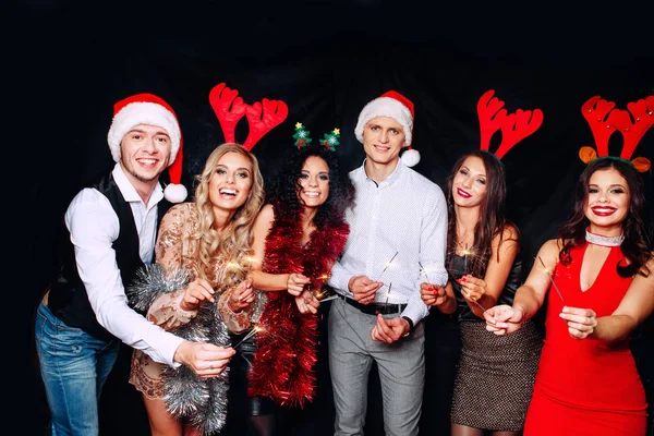 和朋友一起开派对他们喜欢圣诞节一群快乐的年轻人带着火花和香槟酒长笛在新年派对上跳舞，看上去很开心。关于团结生活方式的概念 — 图库照片