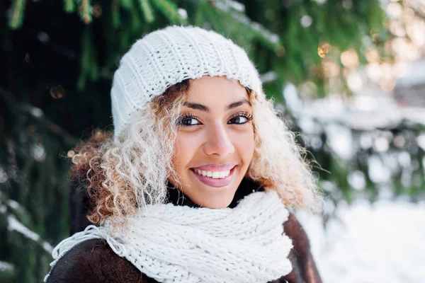 Primer plano retrato de joven hermosa chica con pelo afro en el bosque de invierno. Navidad, concepto de vacaciones de invierno. Nieve . — Foto de Stock