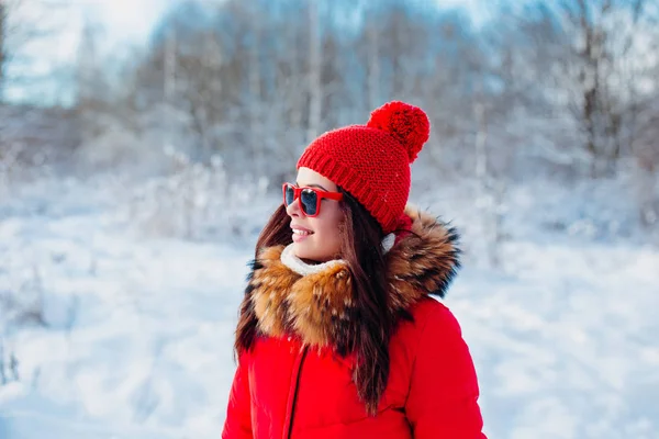Kış arka plan üzerinde kırmızı güneş gözlüğü ile gülümseyen kadın — Stok fotoğraf