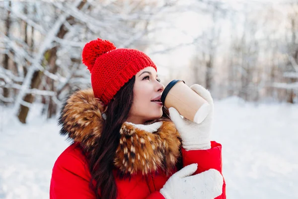 Retrato de jovem mulher bonita no parque de inverno. Beber café e desfrutar da vida . — Fotografia de Stock