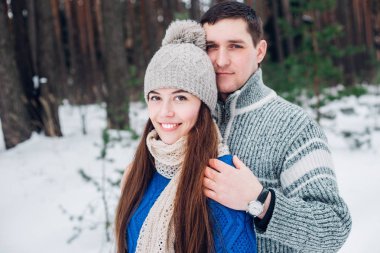 Sarılma ve gülümsüyor kış Park ile kameraya bakarak sevmek çift
