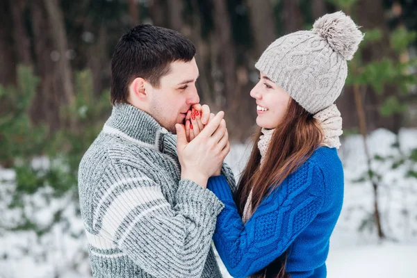 Casal indo frio abrigado no inverno ao ar livre. Homem de mãos dadas sua namorada no parque de inverno — Fotografia de Stock