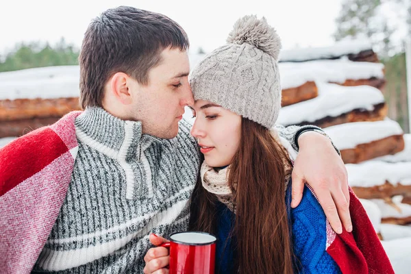 Casal romântico jovem com bebida quente na floresta de inverno. Casal apaixonado — Fotografia de Stock