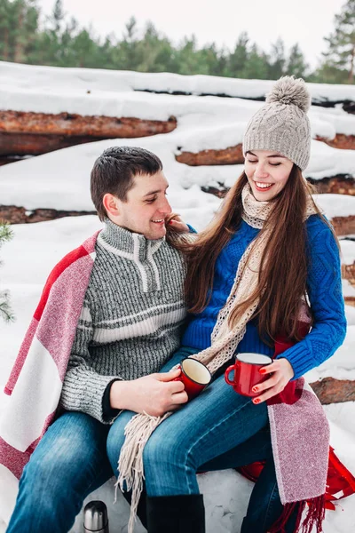 Casal romântico jovem com bebida quente na floresta de inverno. Casal apaixonado — Fotografia de Stock