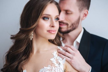 Evlilik çift kapalı birbirlerine sarılma. Beyaz elbiseli güzel model kız. Takım elbiseli adam. Güzellik gelinle damat.