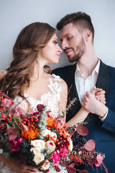 Casamento casal com noiva segurando buquê. Retrato sensual de um jovem casal. Foto do casamento interior — Fotografia de Stock