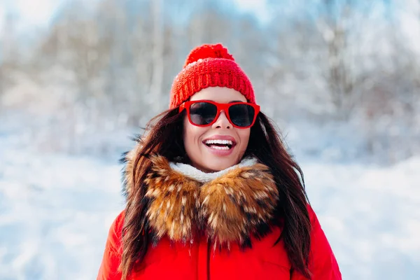 Mujer sonriente con gafas de sol rojas sobre fondo de invierno —  Fotos de Stock