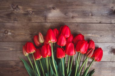 Mesaj alanı olan ahşap arka plan üzerinde kırmızı lale satır. Anneler günü arka plan. Üstten Görünüm. Düz yatıyordu