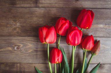 Mesaj alanı olan ahşap arka plan üzerinde kırmızı lale satır. Anneler günü arka plan. Üstten Görünüm.