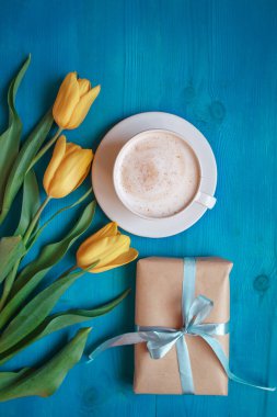 Sarı Lale çiçek ve yukarıdan, annelerin kadın gün veya gün kahvaltı mavi rustik masada mevcut kutusu ile kahve kupa