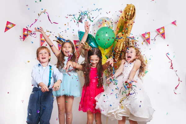 一群漂亮的孩子扔五颜六色的五彩纸屑, 在生日派对上看起来很开心 — 图库照片