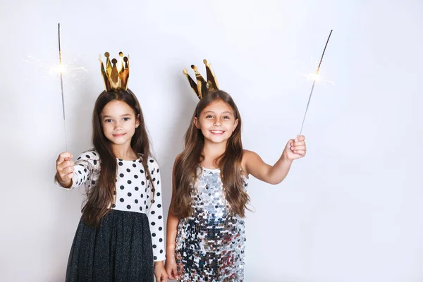 Dos niñas pequeñas y hermosas jugando con un chispeante en la fiesta — Foto de Stock