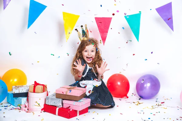 Przyjęcie urodzinowe dla dziecka cute. Mała dziewczynka, rzucanie kolorowy konfetti i patrząc szczęśliwy na urodziny — Zdjęcie stockowe