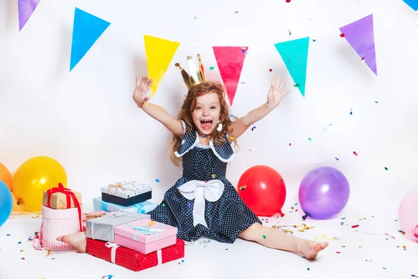 Festa de aniversário para uma criança bonita. Menina jogando confete colorido e olhando feliz na festa de aniversário — Fotografia de Stock