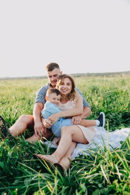 Mutlu aile birlikte yaz günde zevk. Çimenlerin üzerinde oturan aile
