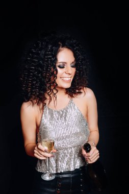 Şişe ve kadeh şampanya ile Noel kutluyor güzel bir genç kadın. Yeni yıl partisi