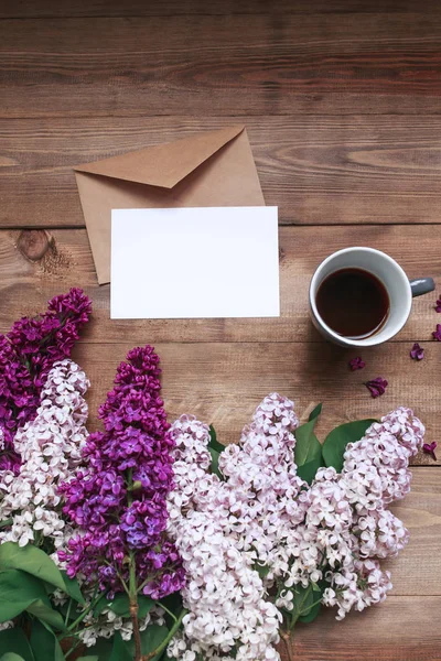 Boeket van lila bloemen op houten planken met lege kaart voor tekst en koffie. Bovenaanzicht — Stockfoto