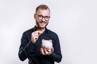 Para kazanmak için piggybank kullanarak gülümseyen işadamı