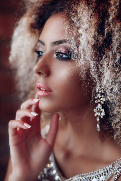 Fashion portrait of young beautiful afro american woman with jewelry and evening make-up.